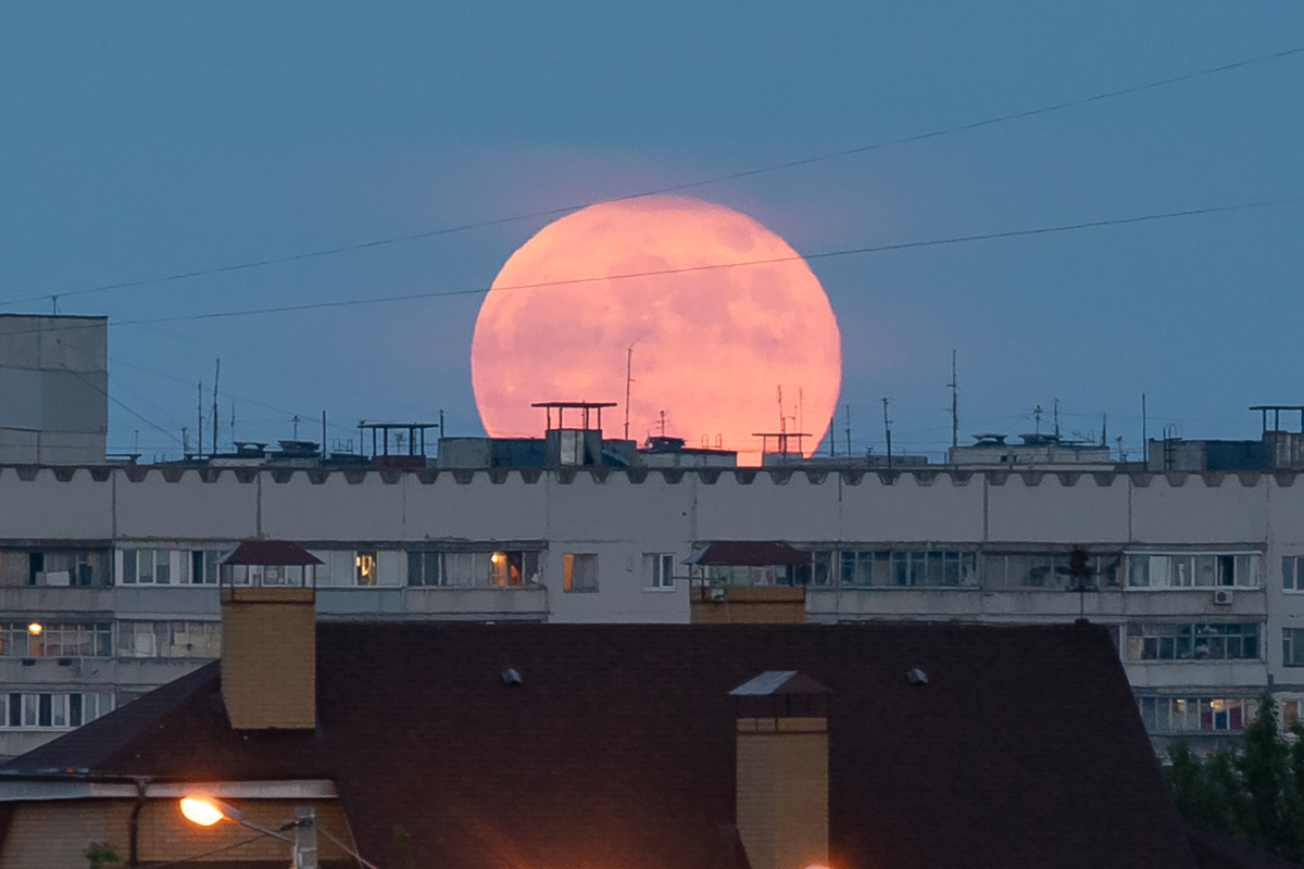Восход полной луны над крышей дома в Харькове