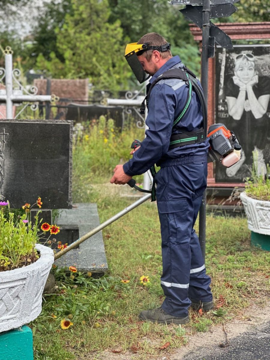 Видаляють пошкоджені обстрілами дерева з кладовища комунальники Харкова